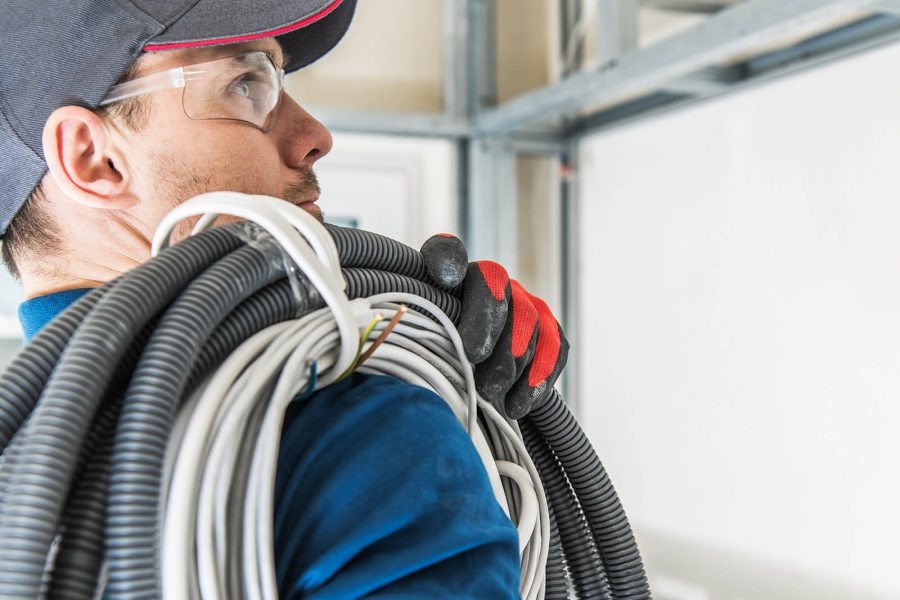 Modern America Electric technician carrying wiring into a job site