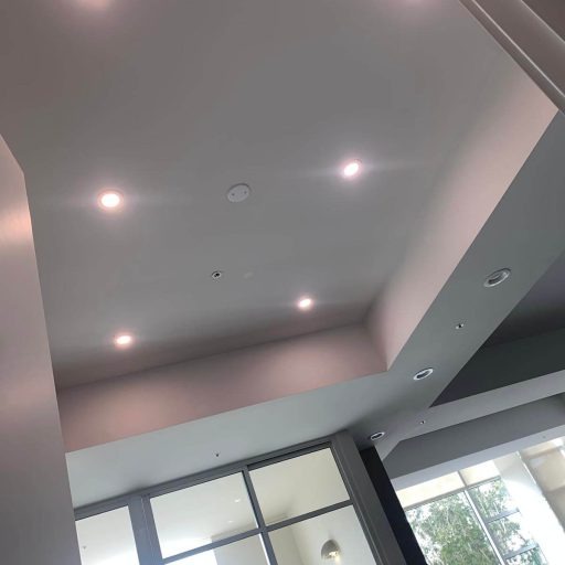 Recessed lighting retrofit underway in a residential hallway